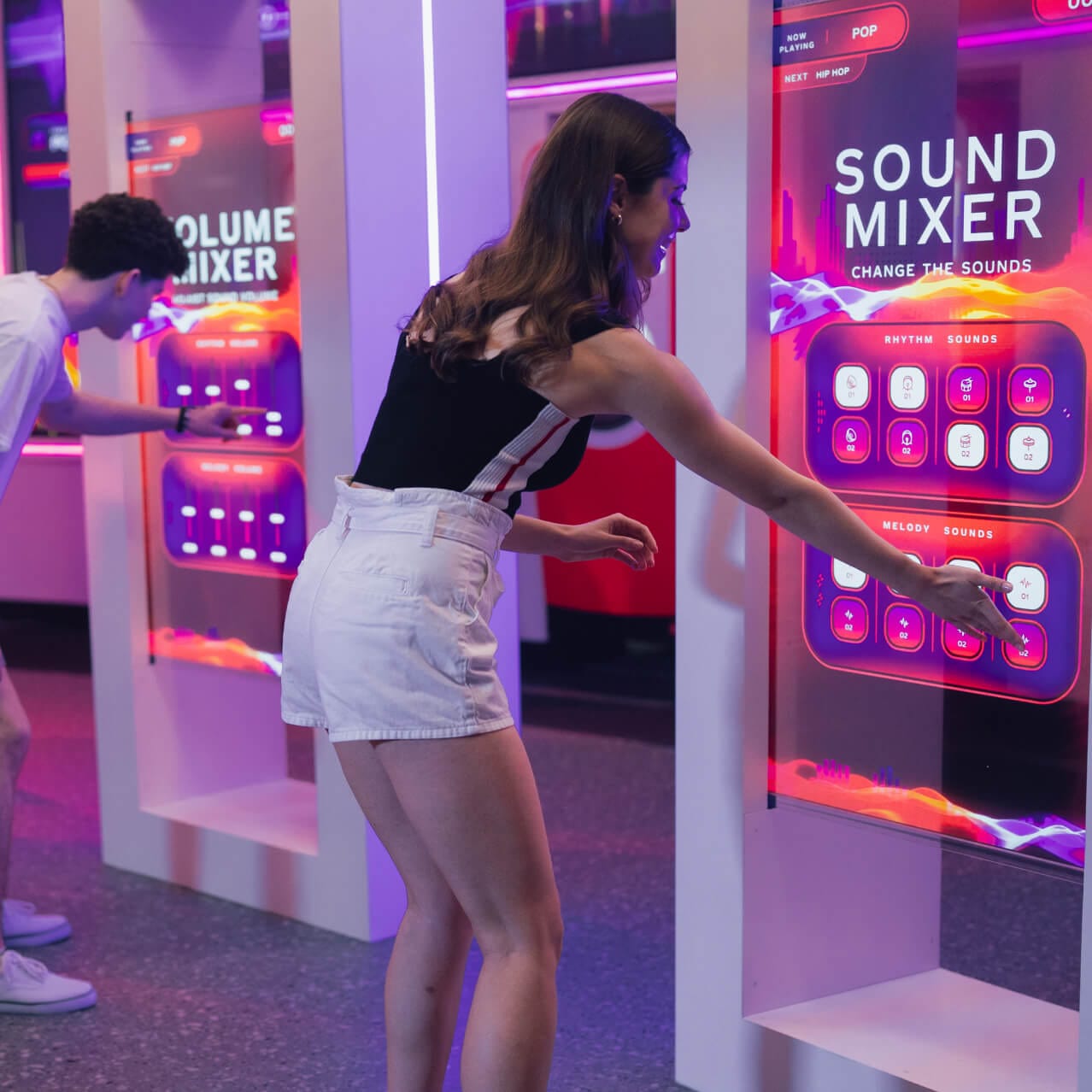 Visitantes interactuando con estaciones de mezcla en Coca-Cola Refresh Lounge de Universal Studios Florida.