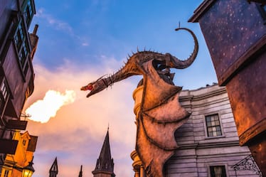 Dragón que lanza fuego posado encima de la entrada a la emocionante atracción Harry Potter and the Escape from Gringotts en Universal Studios Orlando.