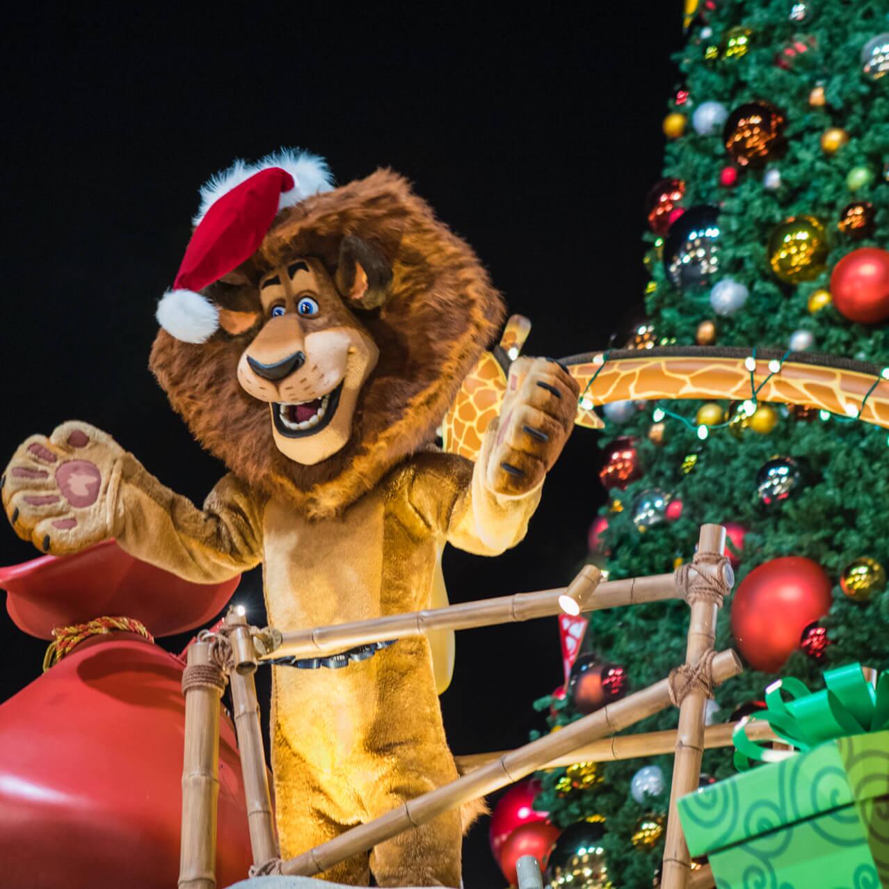 Alex, el león de las películas de Madagascar, viste un sombrero de Santa en una carroza en el desfile Universal's Holiday Parade presentado por Macy's.