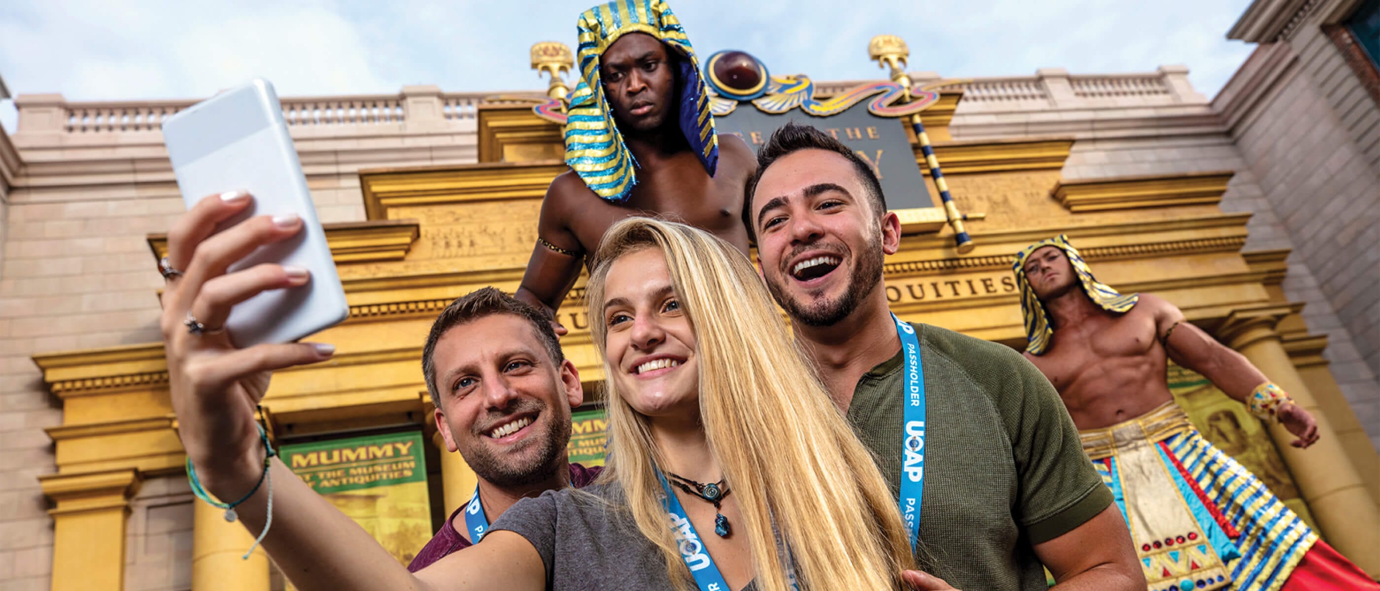 Tres amigos posando para una selfie con los faraones frente a Revenge of the Mummy en Universal Studios Florida.