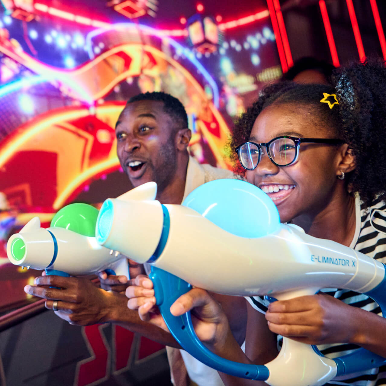 A father and daughter playing Illumination’s Villain-Con Minion Blast at Universal Studios Florida.