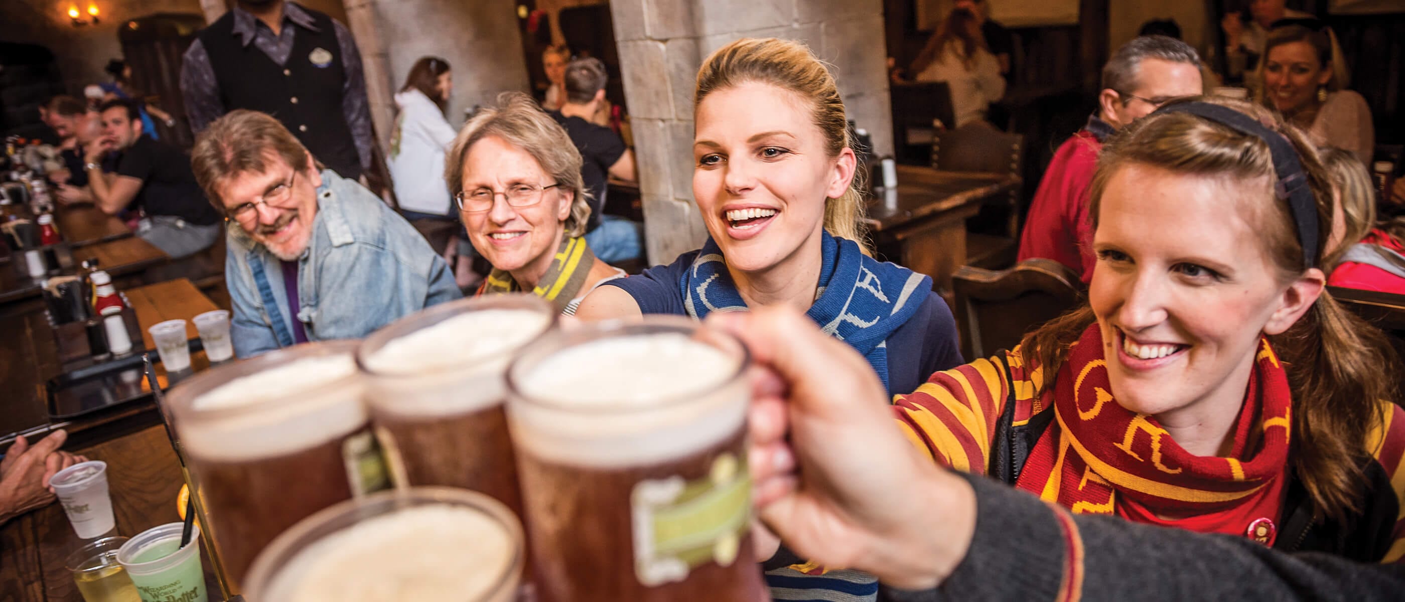 Un grupo de personas brinda con copas de Butterbeer en el restaurante Leaky Cauldron™ en The Wizarding World of Harry Potter™ - Diagon Alley™ de Universal Studios Orlando.