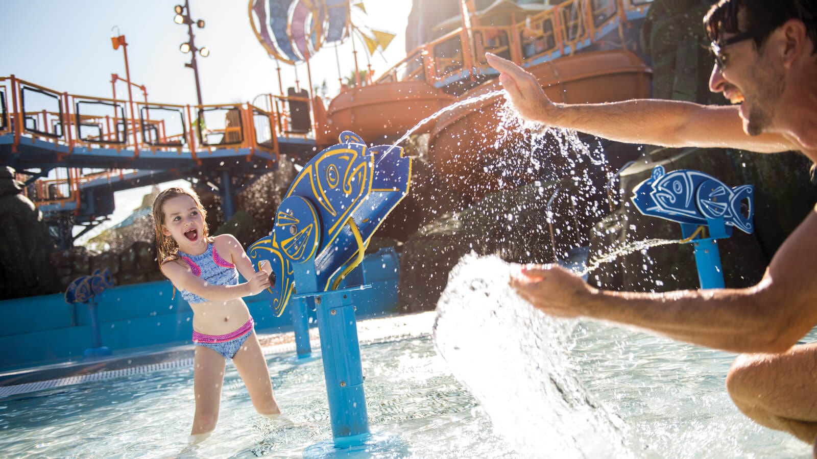 Daughter splashing father with a water gun in Runamukka Reef at Universal Volcano Bay.