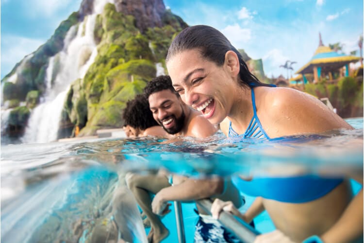 Una pareja se ríe mientras disfruta en la piscina de recreación The Reef, en Universal Volcano Bay.