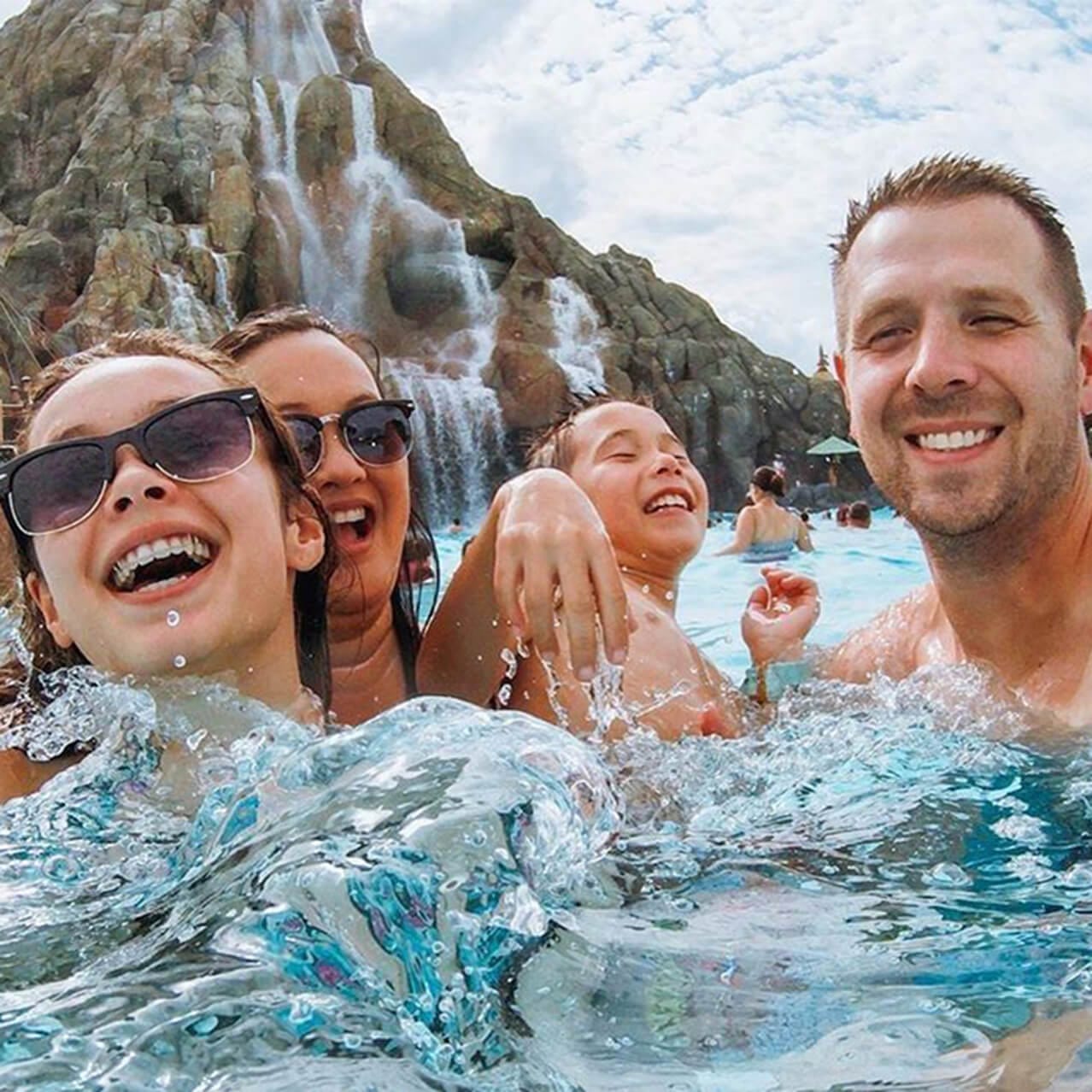 Una familia joven juega en las aguas de Waturi Beach, frente al volcán Krakatau en Universal Volcano Bay.