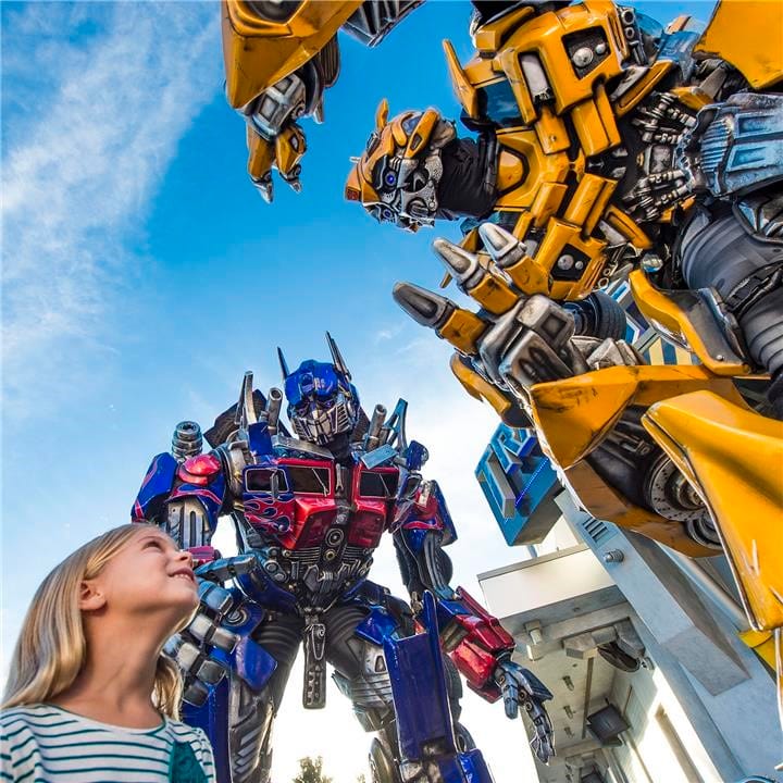 Admira a unos de tus héroes favoritos, incluyendo a Bumblebee y Optimus Prime en Universal Studios Florida en Orlando. Los imponentes Bumblebee y Optimus Prime se agachan para saludar a una niña en Universal Studios™ Orlando.