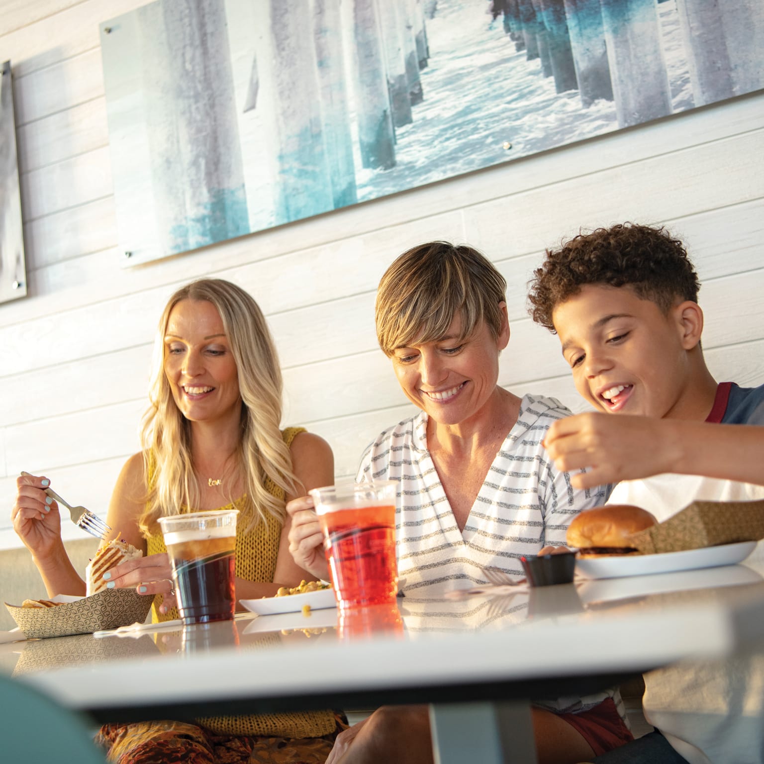 Família senta para saborear uma refeição no Pier 8 Market, a praça de alimentação casual do Universal's Endless Summer Resort – Dockside Inn and Suites.