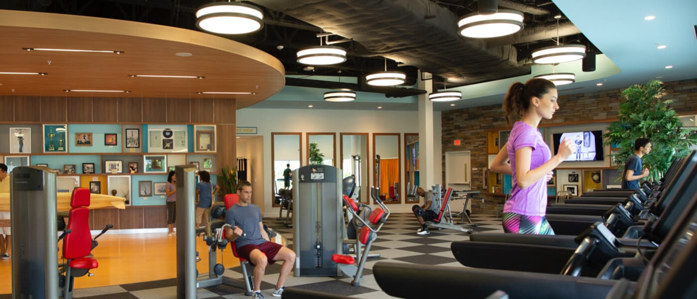 Visitantes correm em esteiras e usam aparelhos de musculação no moderno Jack LaLanne Fitness Studio, um salão de exercícios no Universal Orlando que foi inspirado em um dos mais icônicos defensores da saúde do século XX.