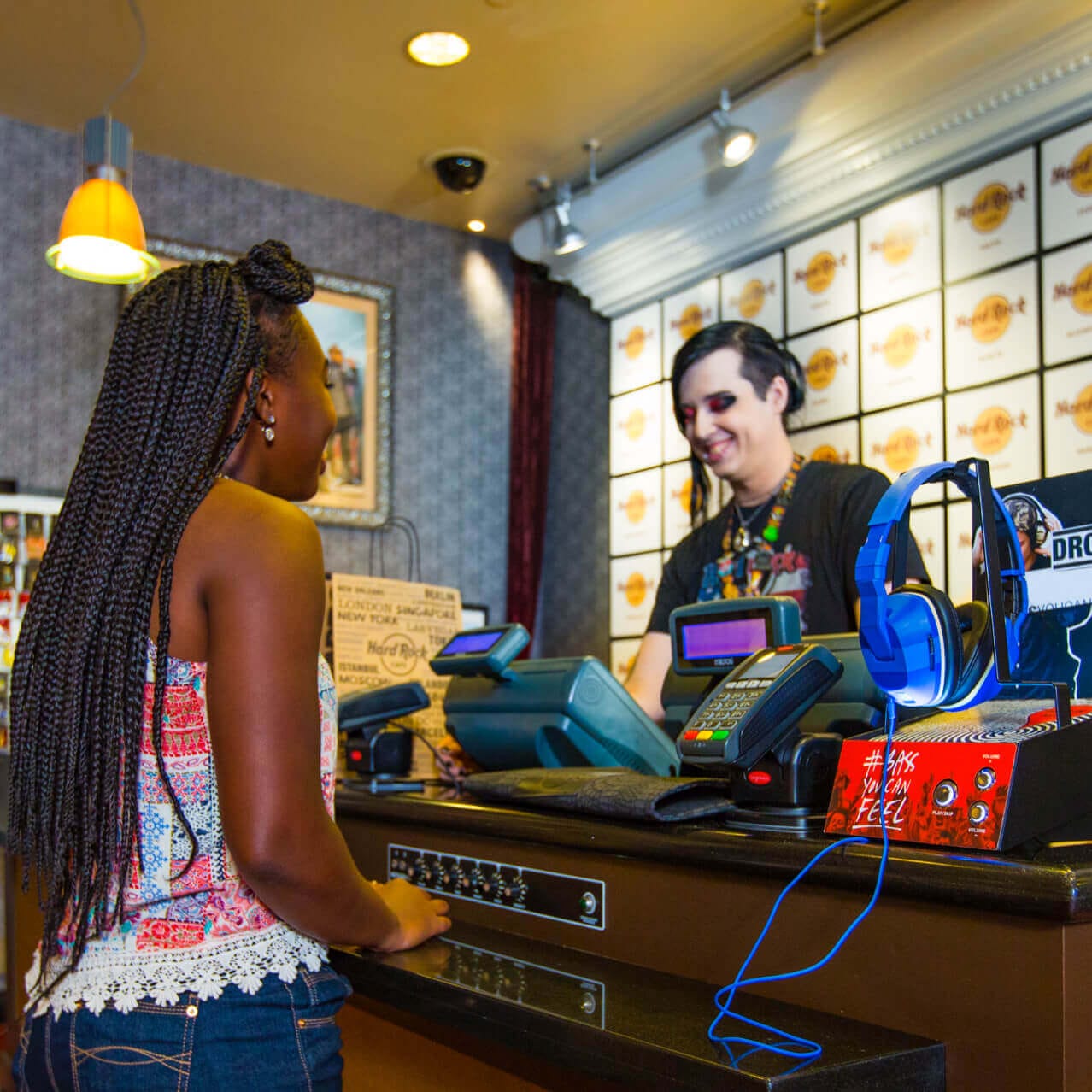 Uma garota fica no caixa enquanto um funcionário registra sua compra na Rock Shop do Hard Rock.