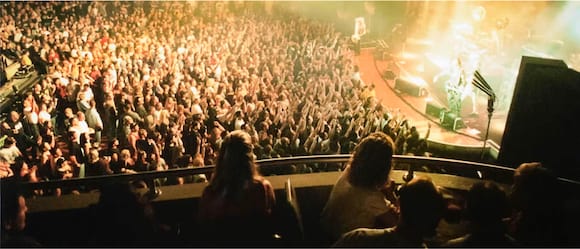 Looking down from the balcony seats inside Hard Rock Live onto the crowd below viewing a brightly lit concert.