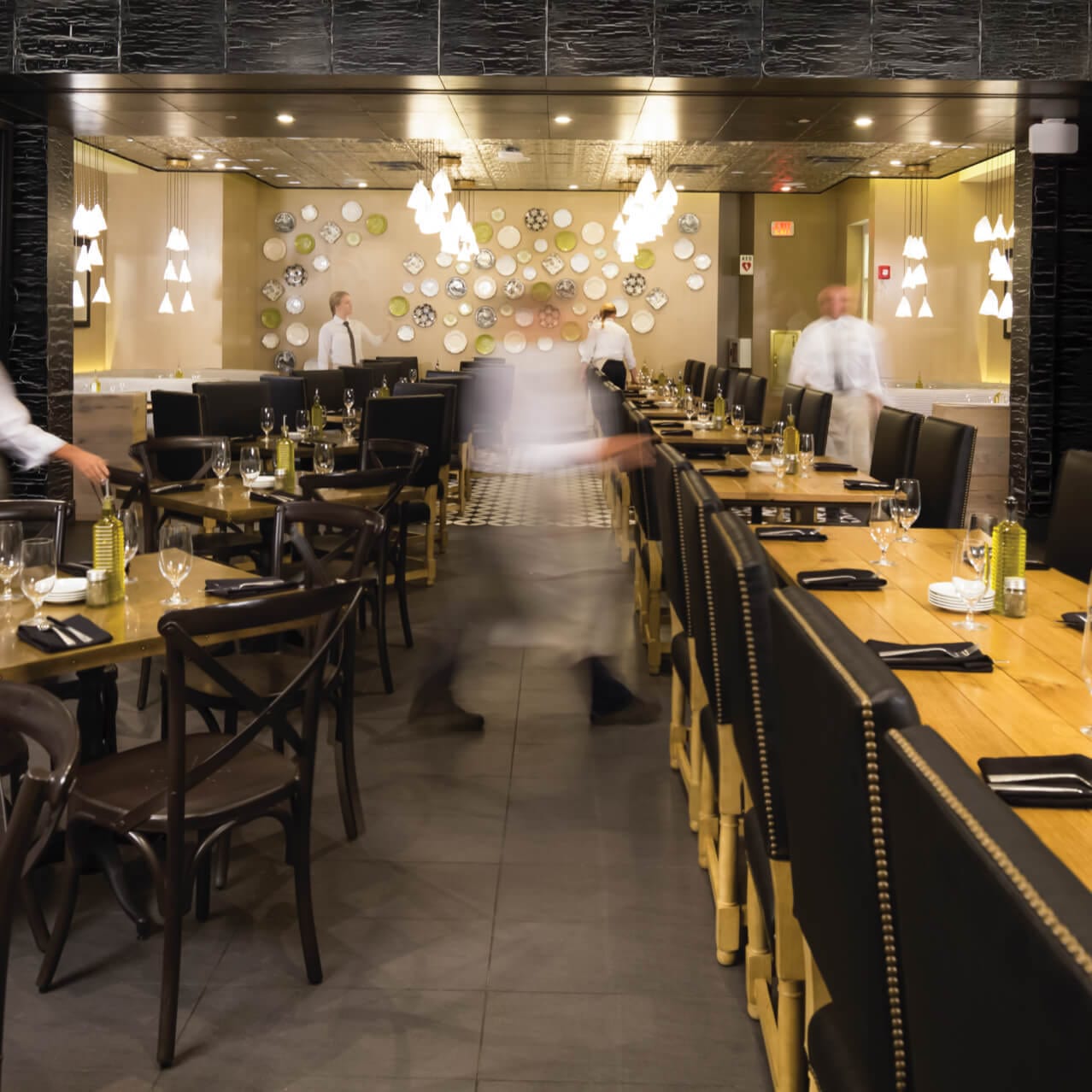 Os garçons passam por longas mesas de jantar dentro do Vivo Italian Kitchen no Universal CityWalk.