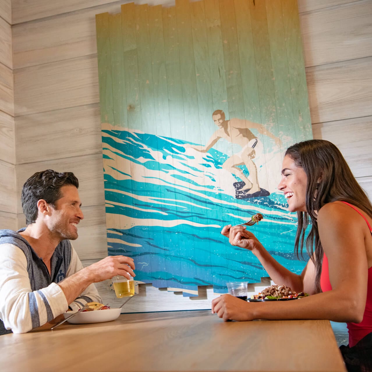 Um casal desfrutando de sua refeição no Beach Break Cafe no Surfside Inn and Suites.