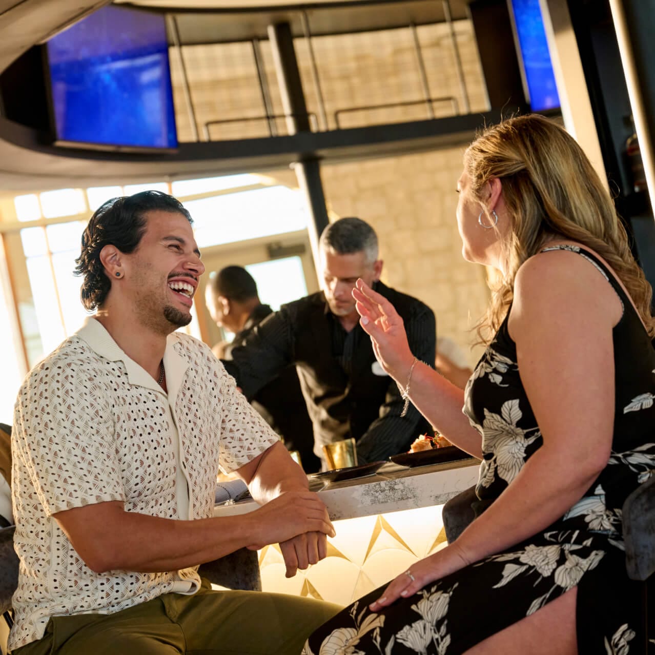 Casal rindo no Bar Helios, dentro do Universal Helios Grand Hotel, a Loews Hotel