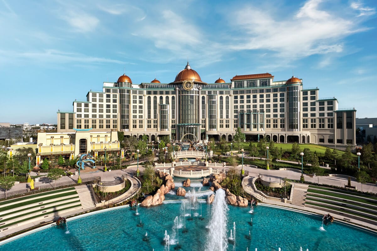 Vista do Universal Helios Grand Hotel, a Loews Hotel, com suas torres redondas que se erguem por trás de uma grande fonte de vários níveis e jardins paisagísticos.