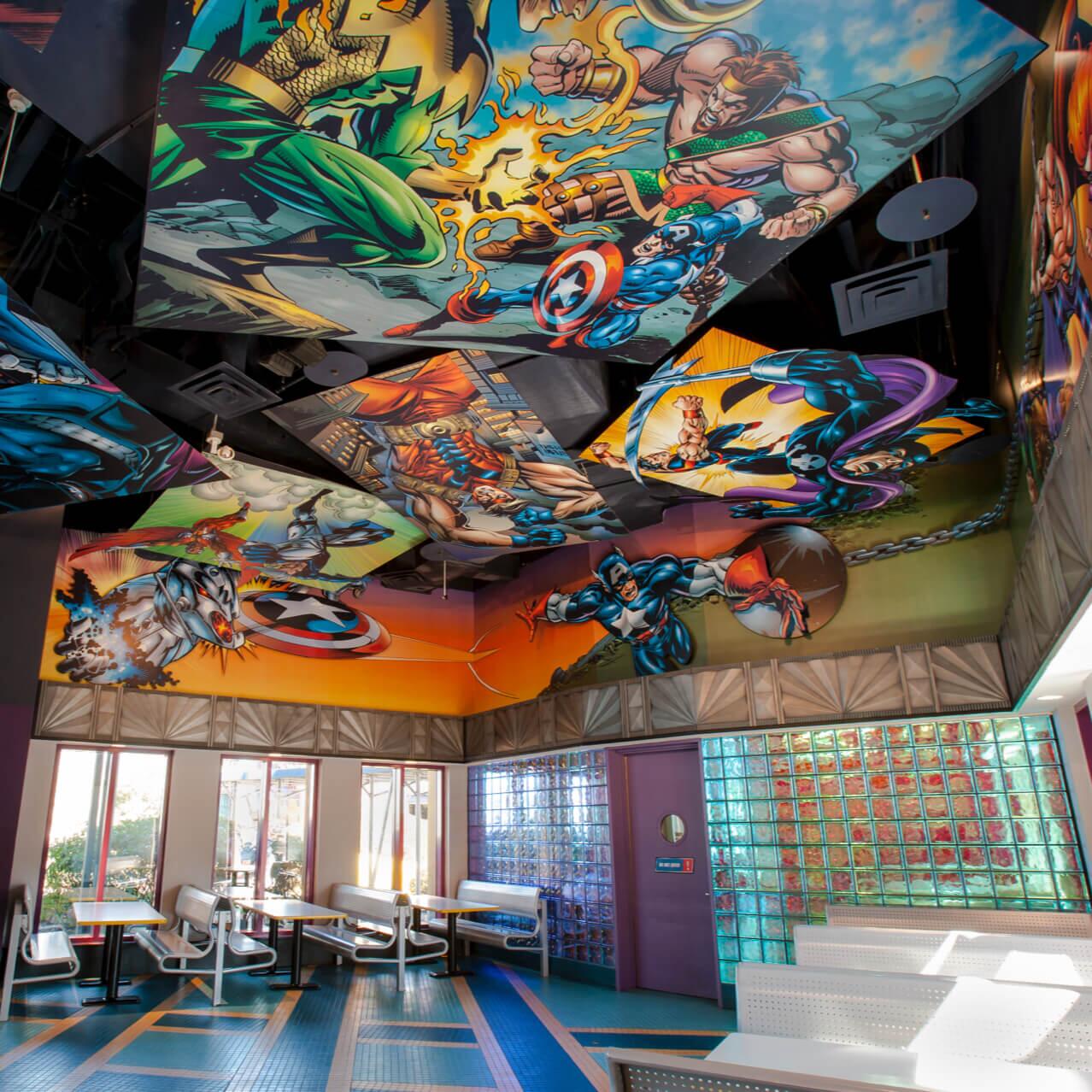 O interior do Captain America Diner no Universal Orlando, decorado de cima a baixo com cores vivas e ilustrações de quadrinhos.