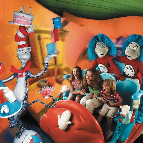 Coisa Um e Coisa Dois juntam-se a uma família em um vagão da atração The Cat in the Hat em Seuss Landing no Universal's Islands of Adventure, em Orlando.