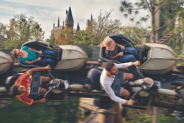 Hagrid's Magical Creatures Motorbike Adventure™ passa voando com o castelo de Hogwarts™ ao fundo.