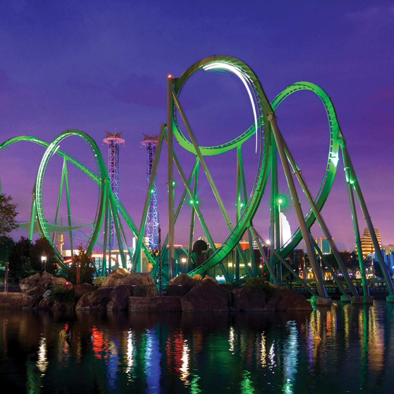 Vista noturna dos trilhos verdes do Incredible Hulk Coaster que se estende pela Marvel Super Hero Island, no Universal Orlando Resort.