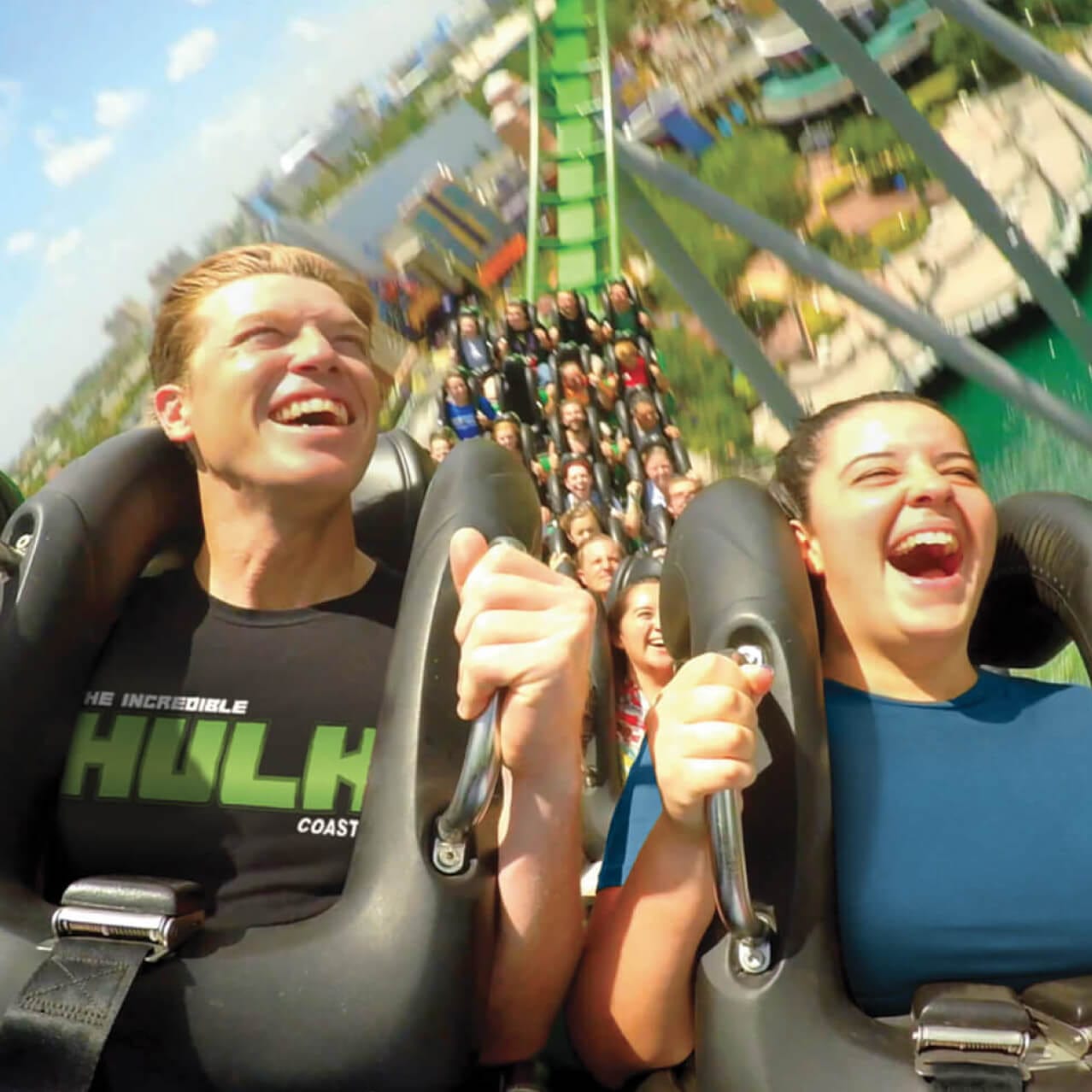 Close de visitantes sorrindo enquanto andam na montanha-russa The Incredible Hulk, no Universal's Islands of Adventure.