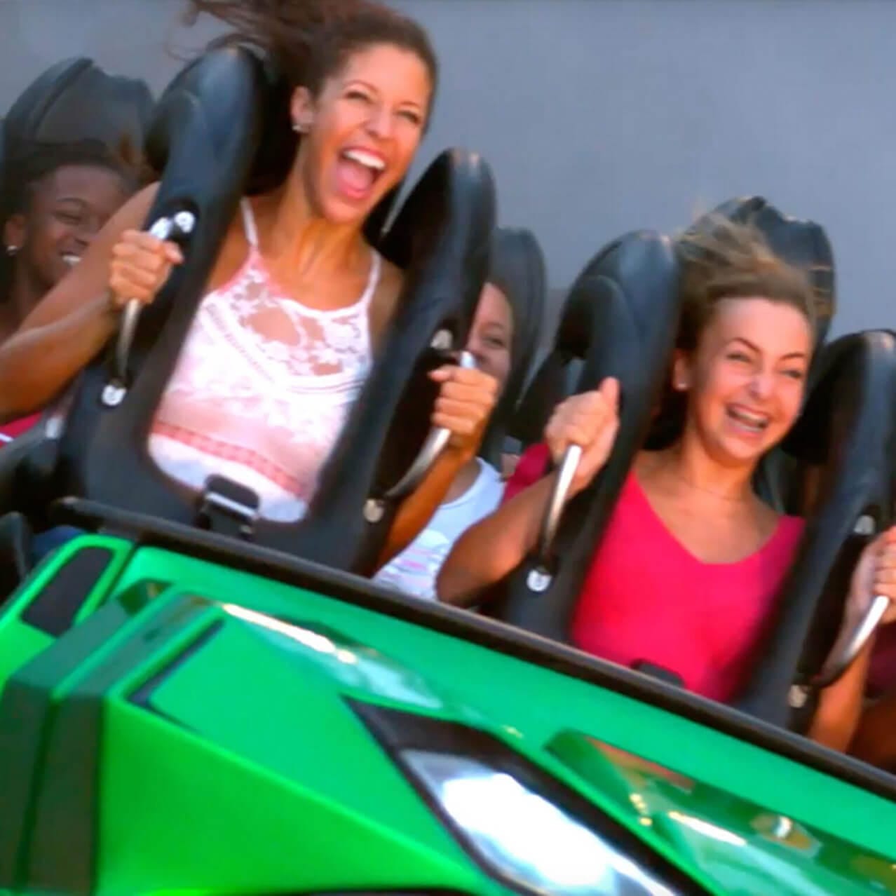 Duas mulheres sorriem e seguram firme enquanto andam no The Incredible Hulk Coaster no Universal's Islands of Adventure Orlando.