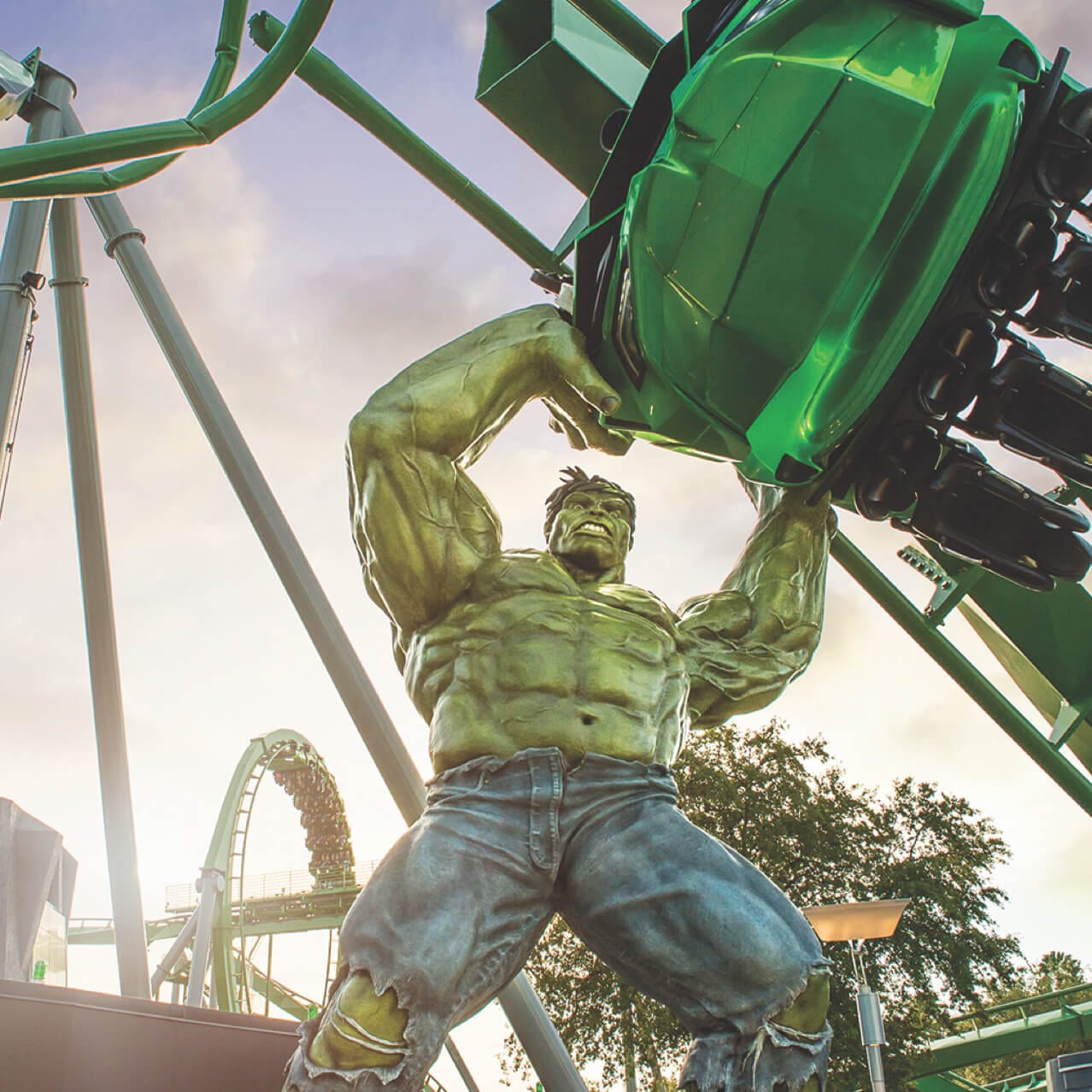Uma estátua gigante do Hulk segura um veículo de passeio na entrada do The Incredible Hulk Coaster.