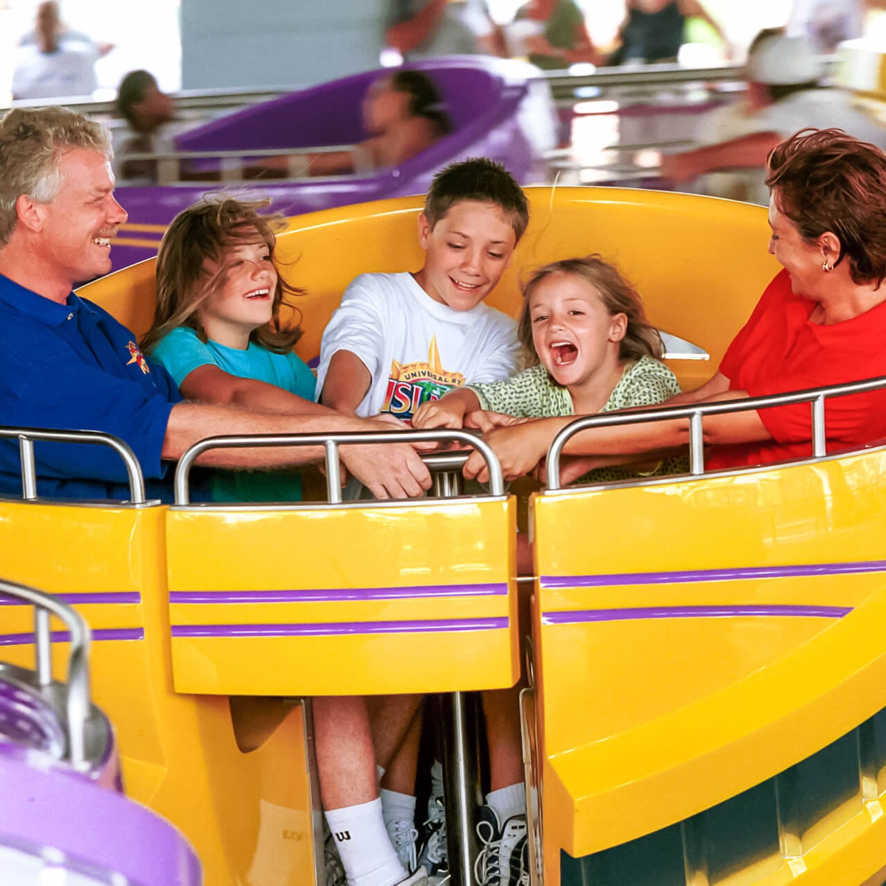 Uma família rodopia na Storm Force Accelatron, uma atração giratória na Marvel Super Hero Island do Universal Orlando.
