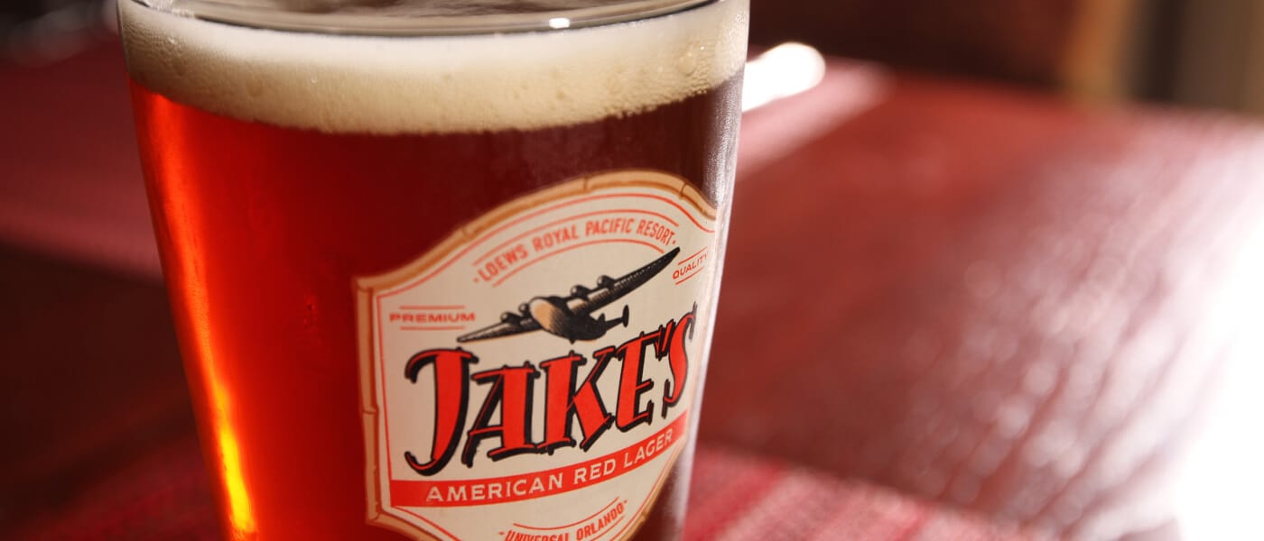 Homem com uma garrafa de cerveja na mão enchendo um copo no evento Jake's Beer Festival no Universal Orlando Resort.