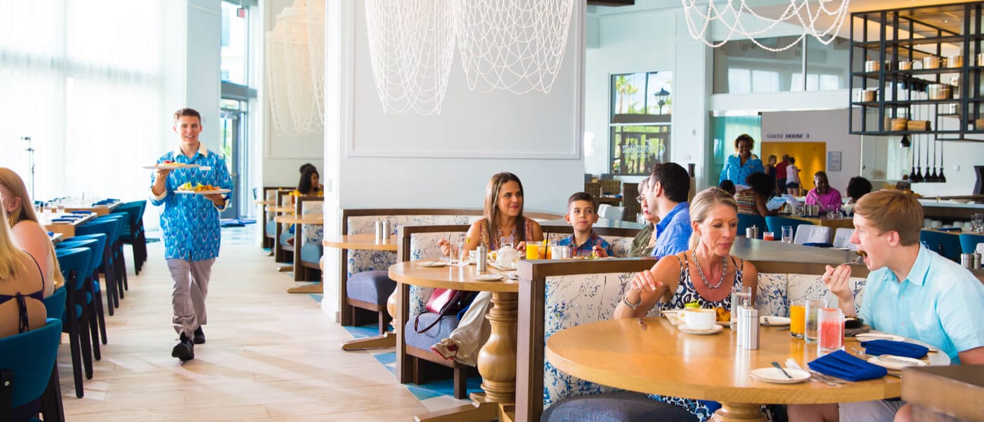 Os visitantes sentados em cabines elegantes comem dentro do Amatista Cookhouse, o restaurante principal do Loews Sapphire Falls no Universal Orlando Resort.