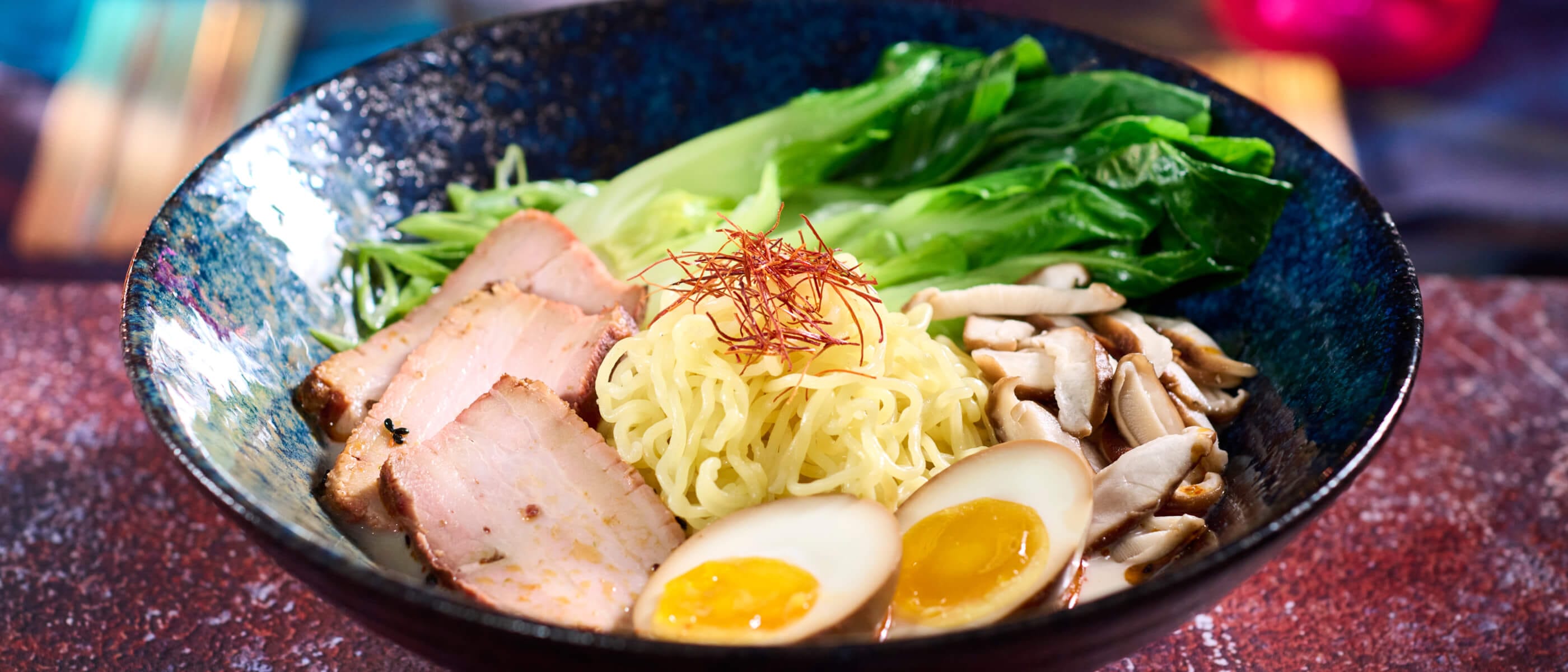 Tonkotsu Ramen com carne de porco chashu macia, ovo com tarê e cogumelos shiitake, servido no The Blue Dragon Pan Asian Restaurant.