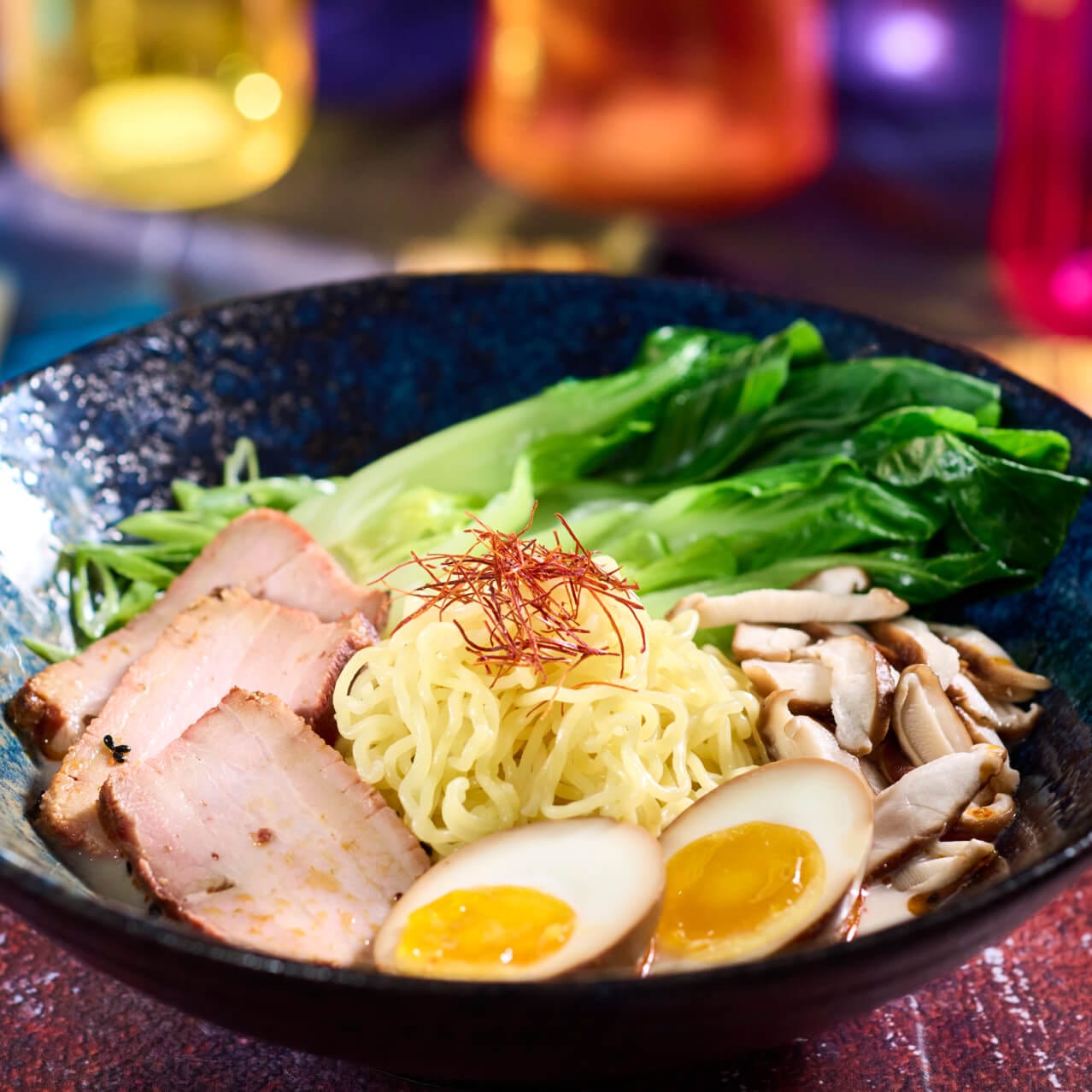 Tonkotsu Ramen com carne de porco chashu macia, ovo com tarê e cogumelos shiitake, servido no The Blue Dragon Pan Asian Restaurant.
