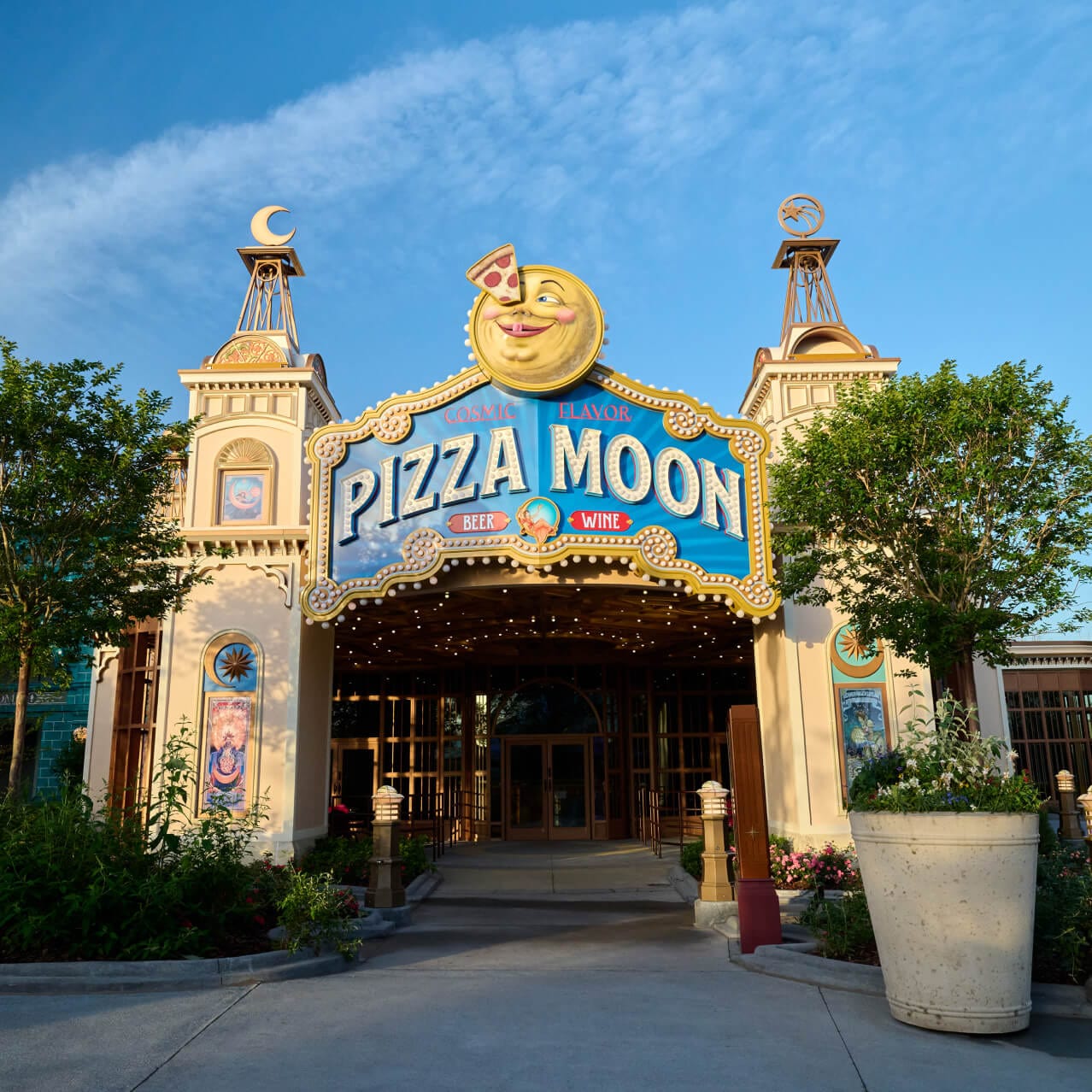 A entrada temática de teatro do Pizza Moon, com uma grande placa suspensa que inclui uma lua sorridente com uma fatia de pizza sobre um olho.