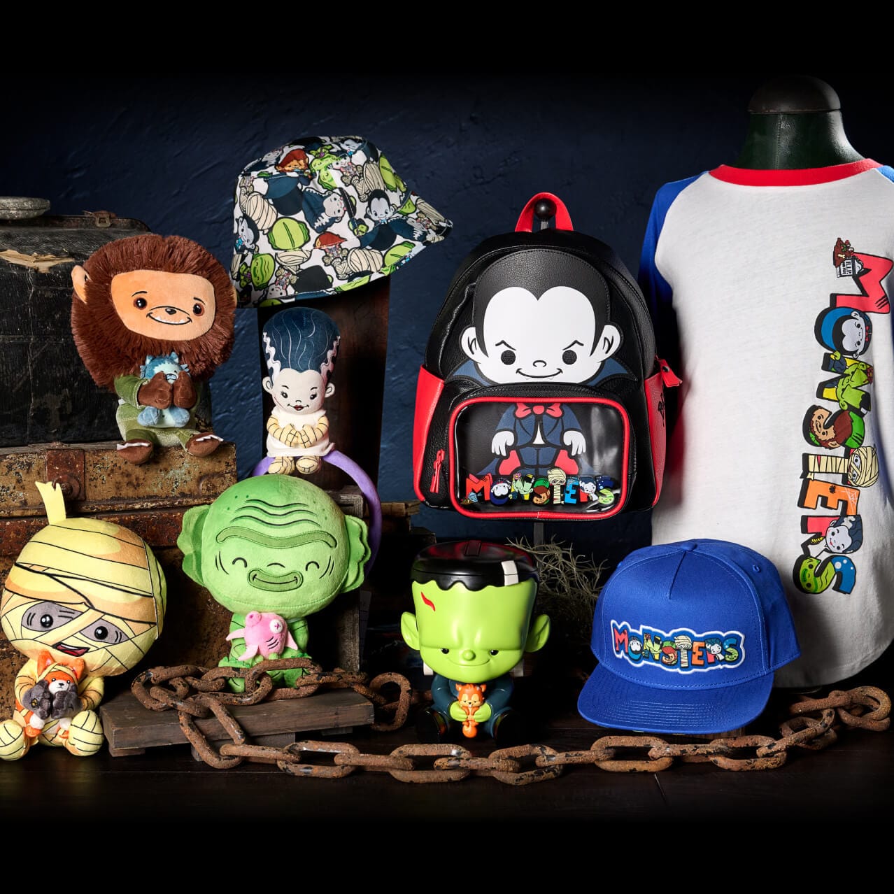 Exposição de produtos infantis do Dark Universe, incluindo bichinhos de pelúcia de personagens monstruosos, chapéus, mochilas e camisetas.