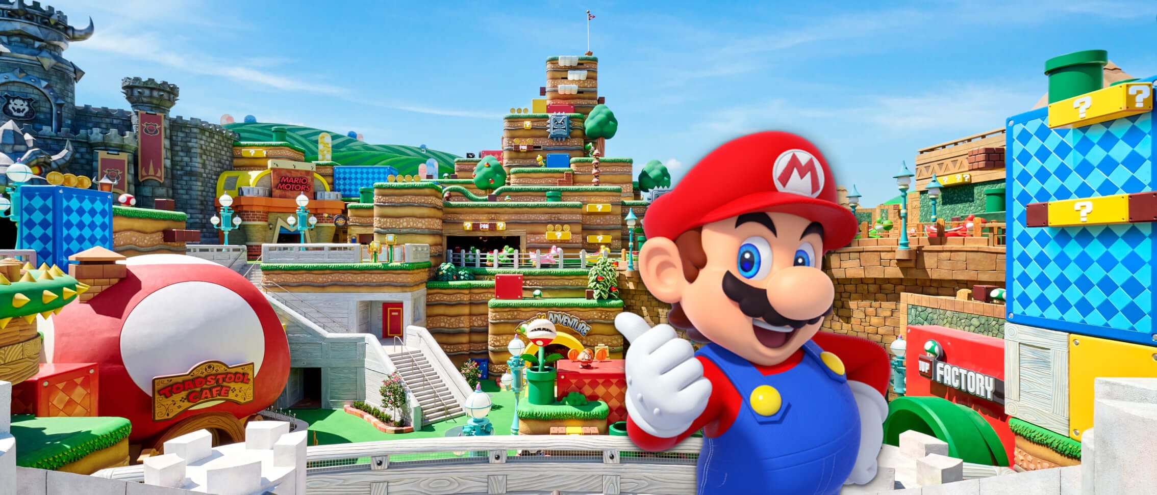 Mario sorrindo e dando uma joinha em frente ao SUPER NINTENDO WORLD™ no Universal Epic Universe.