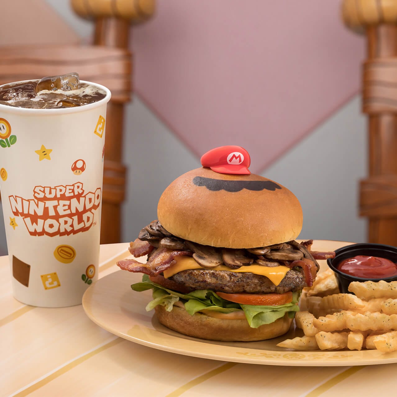 Um hambúrguer Mario Burger de carne bovina do com cogumelos, alface fresca, tomate e queijo americano derretido, em um pão brioche com batatas fritas, disponível no Toadstool Cafe, localizado no SUPER NINTENDO WORLD™.