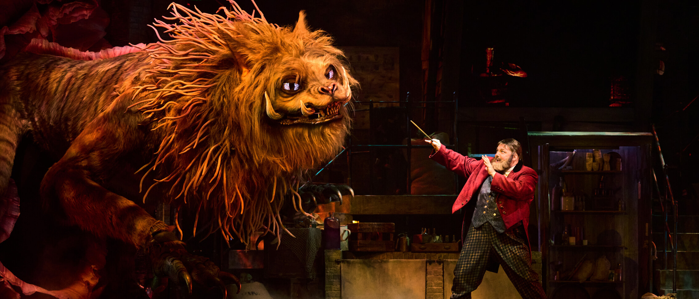 A giant magical Manticore steps toward ringmaster Skender on stage during a performance at Le Cirque Arcanus.