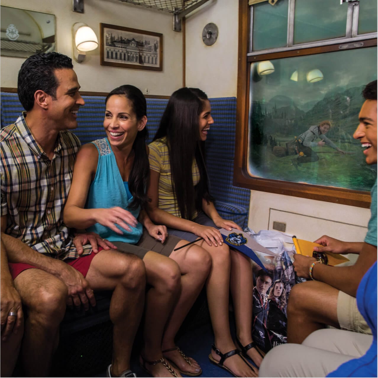 Uma família a bordo do Hogwarts™ Express, um passeio de trem que transporta os visitantes entre o Universal Studios Florida e o Universal's Islands of Adventure Orlando no The Wizarding World of Harry Potter.
