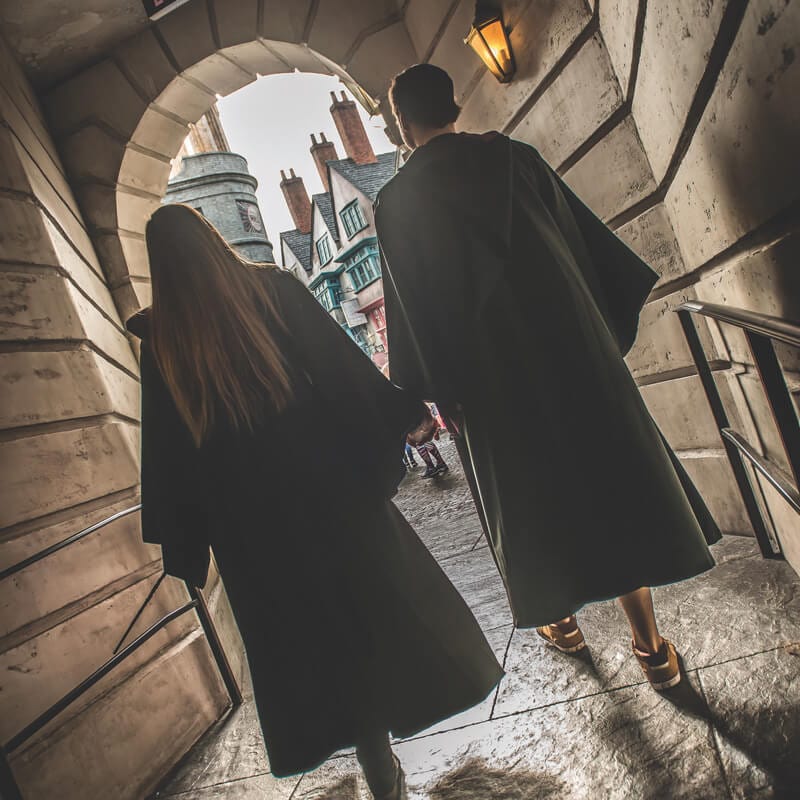 Dois jovens com vestes de Hogwarts entram no Diagon Alley.