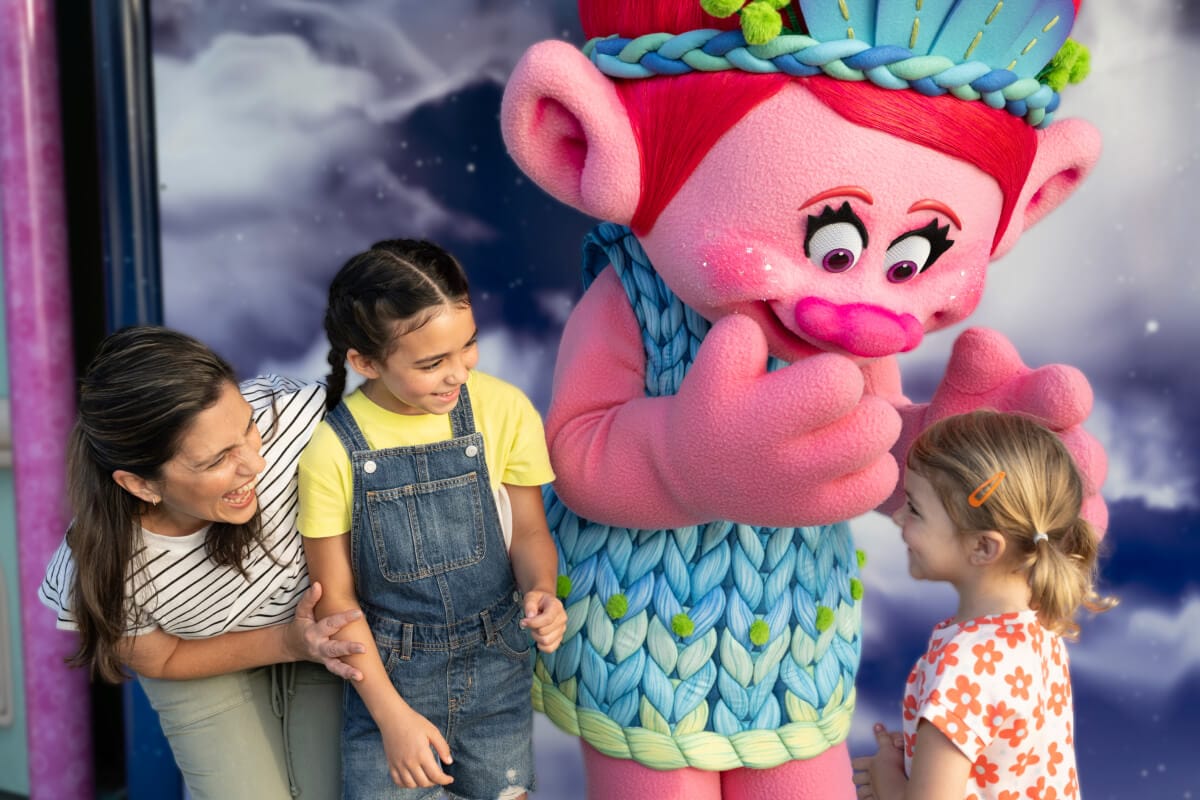 Two children and their mom meeting with Poppy at the DreamWorks Character Zone.
