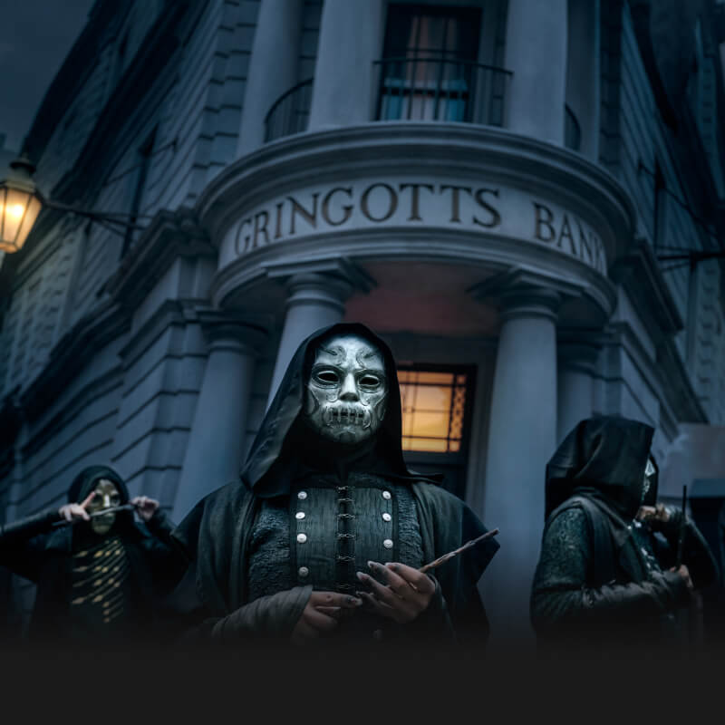 Três Comensais da Morte em frente ao Banco Gringotes à noite