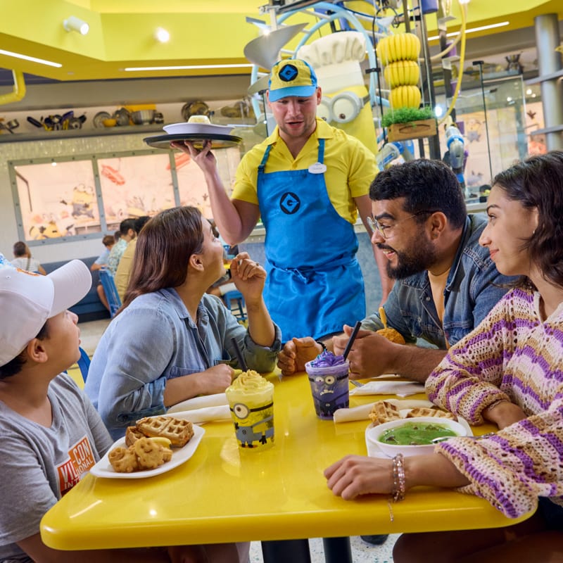 Família aproveitando uma refeição na Illumination’s Minion Cafe, no Universal Studios Florida.