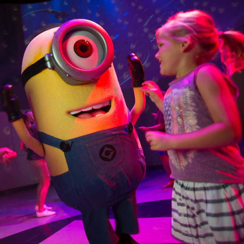 Um Minion dança com fãs animados durante a festa de dança Minion, que ocorre logo após os visitantes passearem na atração