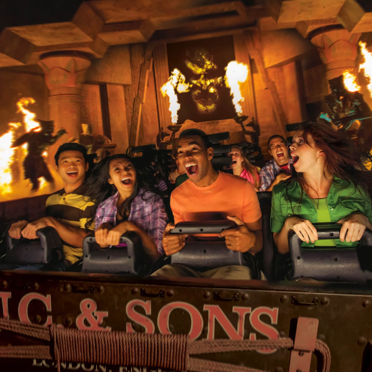 Um grupo de jovens adultos está cercado por efeitos de chamas e artefatos antigos em Revenge of the Mummy, no Universal Studios Florida em Orlando.