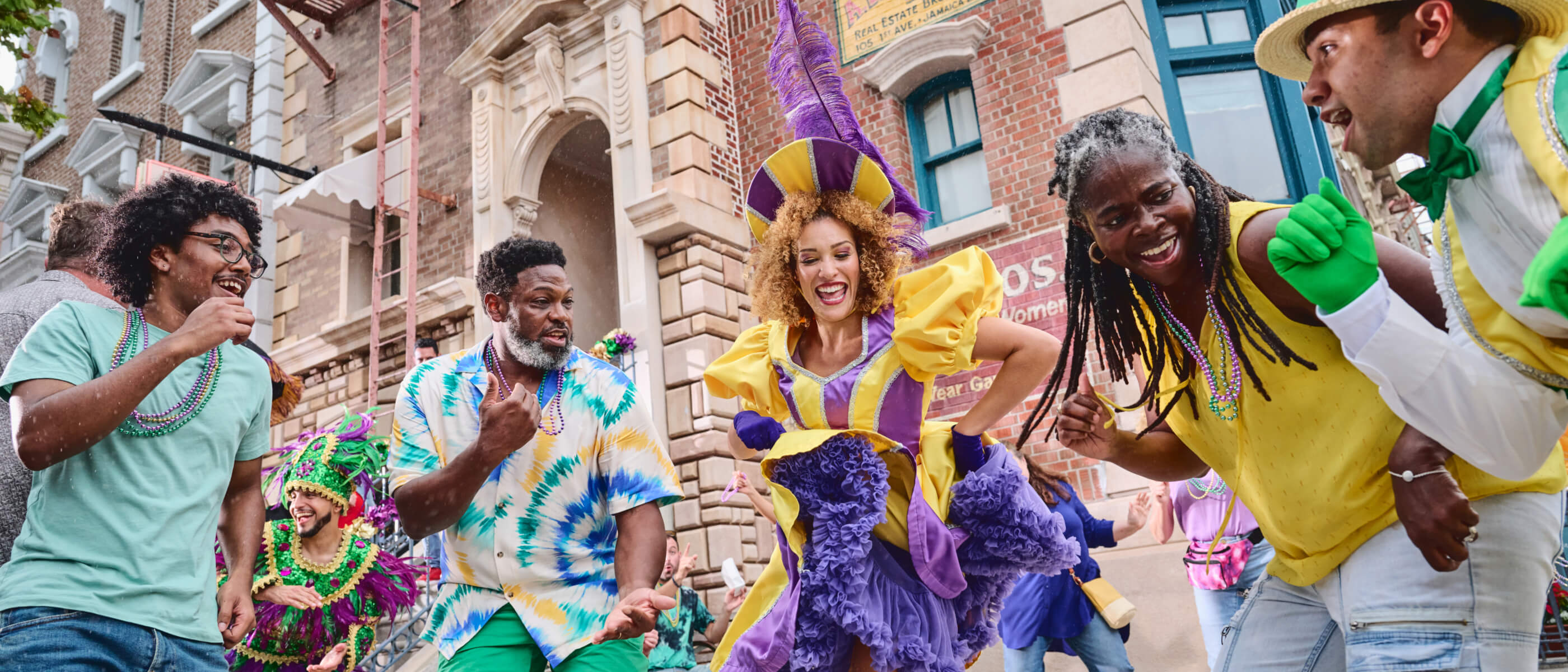 A family dances along with costumed performers while enjoying Universal Mardi Gras: International Flavors of Carnival.