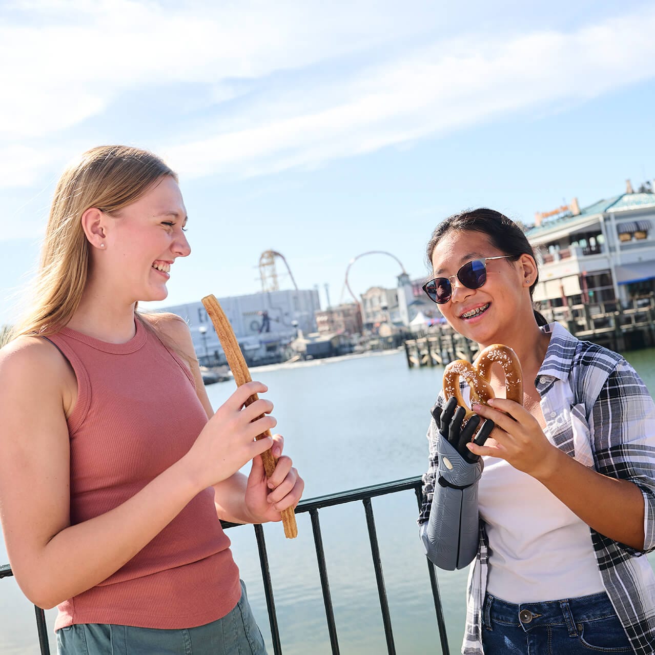 Duas garotas desfrutando de lanches enquanto apreciam a vista da lagoa no Universal Studios Florida.