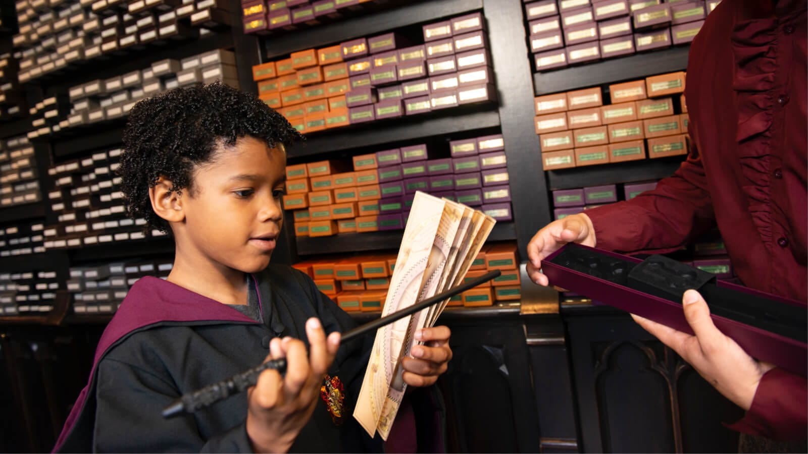 Uma criança segurando uma varinha na loja de varinhas Ollivanders™