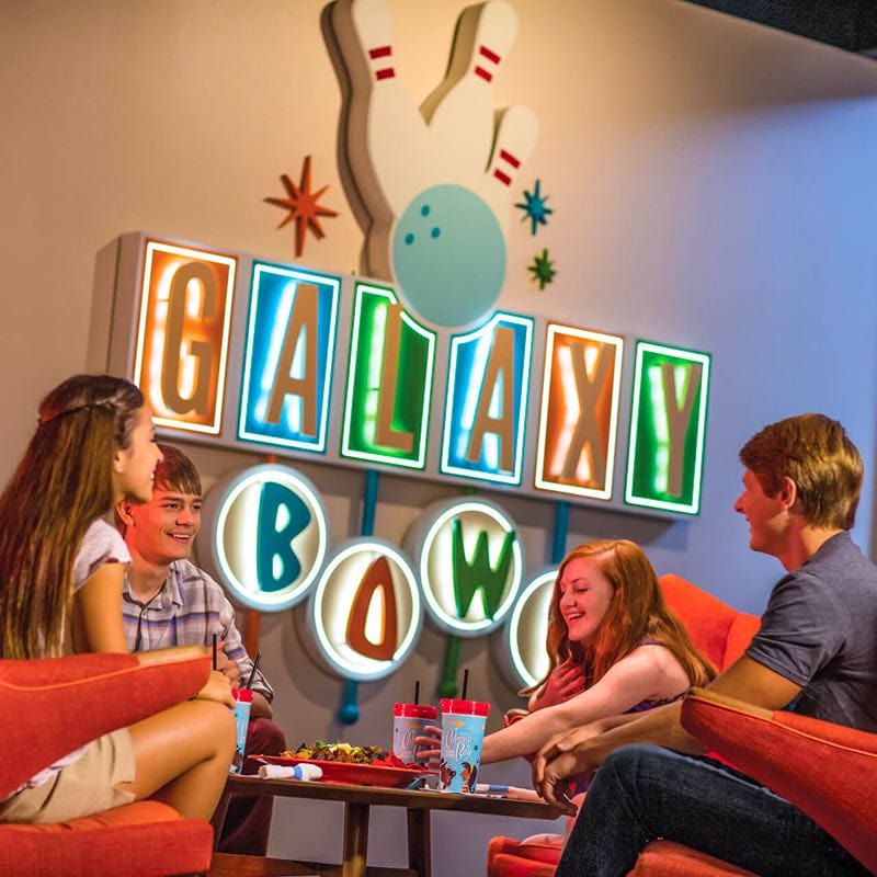 Siblings eating at the restaurant near the Galaxy Bowl sign