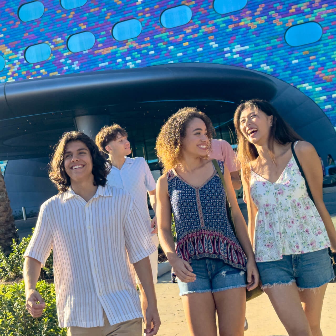 A group of friends smiling at each other at the entrance of Universal Stella Nova Resort.