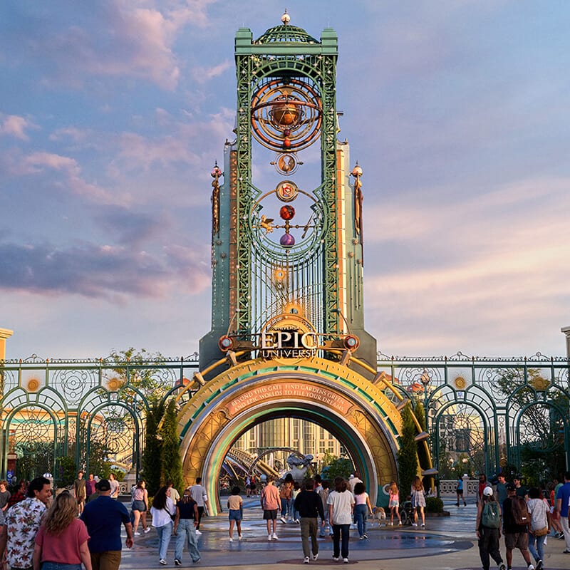 Guests seen walking through the arch of The Chronos Tower at Universal Epic Universe.