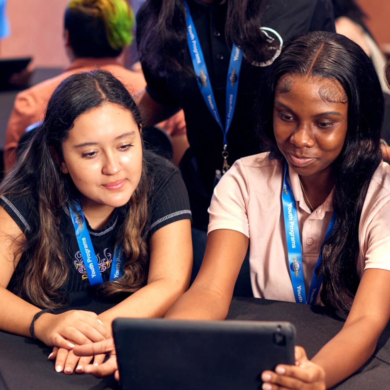 Business Learning Series students sitting at a table looking intently at a tablet