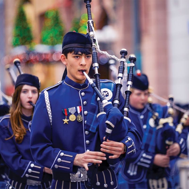 Youth as part of the STARS program in the holiday parade playing a bagpipe